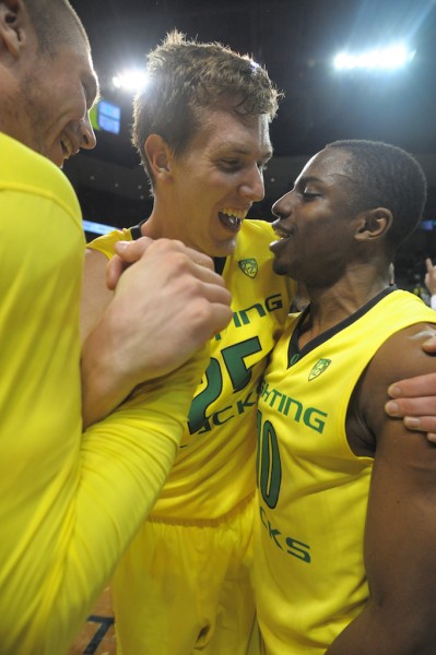 E.J. Singler (center) celebrates with Jonathan Loyd (right) after the Ducks' 70-66 victory over the Arizona Wildcats. (Photo by Rockne Andrew Roll)