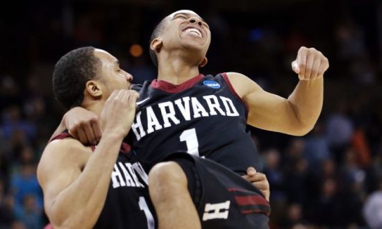 Harvard's Siyani Chambers, right, leaps into the arms of teammate Brandyn Curry after the team beat Cincinnati in the second round of the NCAA college basketball tournament in Spokane, Wash., Thursday, March 20, 2014. Harvard won 61-57. (AP Photo/Elaine Thompson)