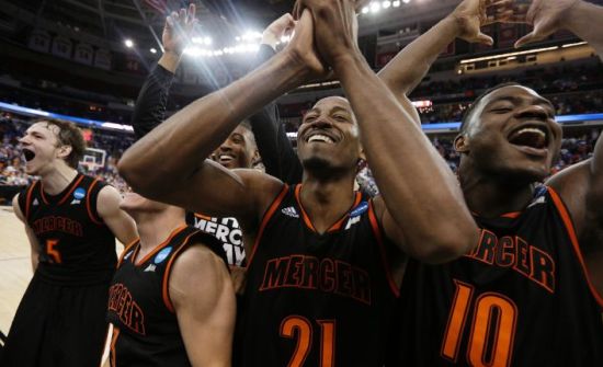 Mercer guard Langston Hall (21) and other Mercer players celebrate after the second half of an NCAA college basketball second-round game against Duke, Friday, March 21, 2014, in Raleigh, N.C. Mercer won 78-71. (AP Photo/Chuck Burton)
